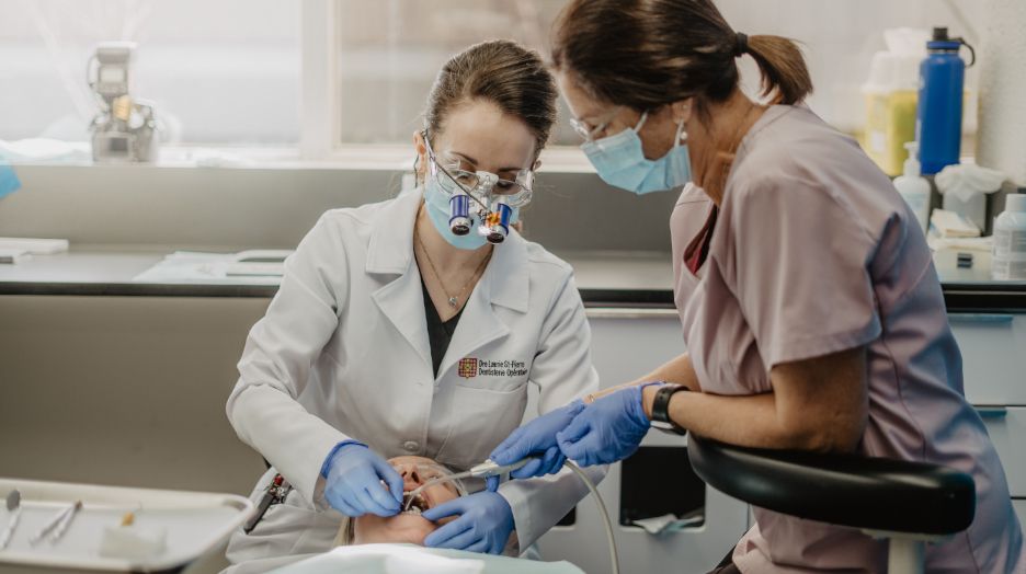 Une professeure et une hygiéniste traitant une patiente